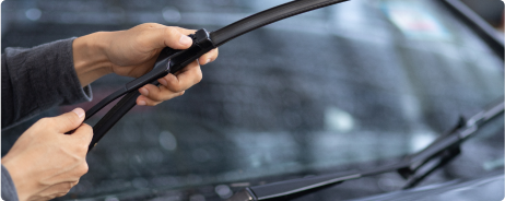 Hands holding window wipers out from car